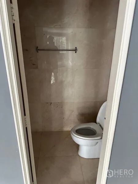 Townhouse for rent in Bang Kapi, Bangkok - Small tiled bathroom with toilet and towel rail.