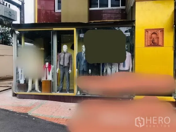 Retail Space for rent in Watthana, Bangkok - Street-front retail shop with full-height glass display windows, gold facade, and mannequins in suits offering high visibility.