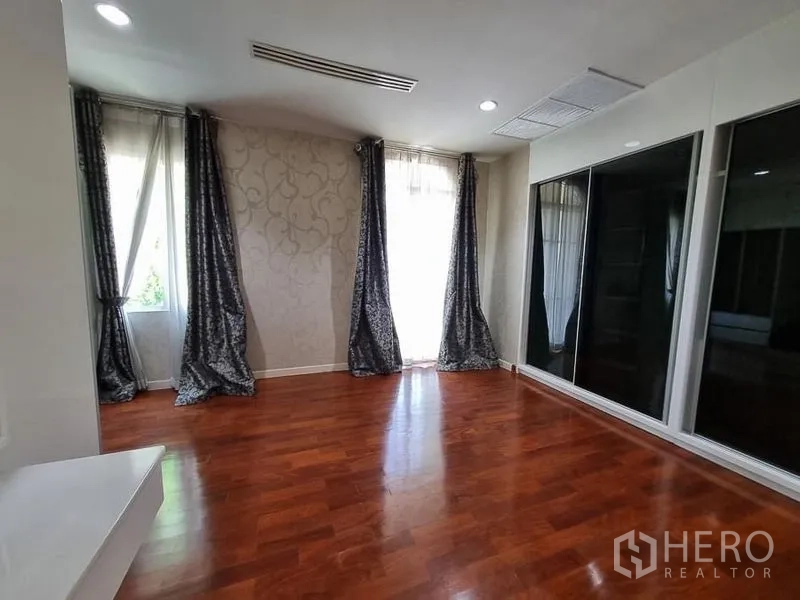 Detached House for rent in Yan Nawa, Bangkok - Flexible room with glossy wood flooring, corner windows with drapes and a large mirrored wardrobe.