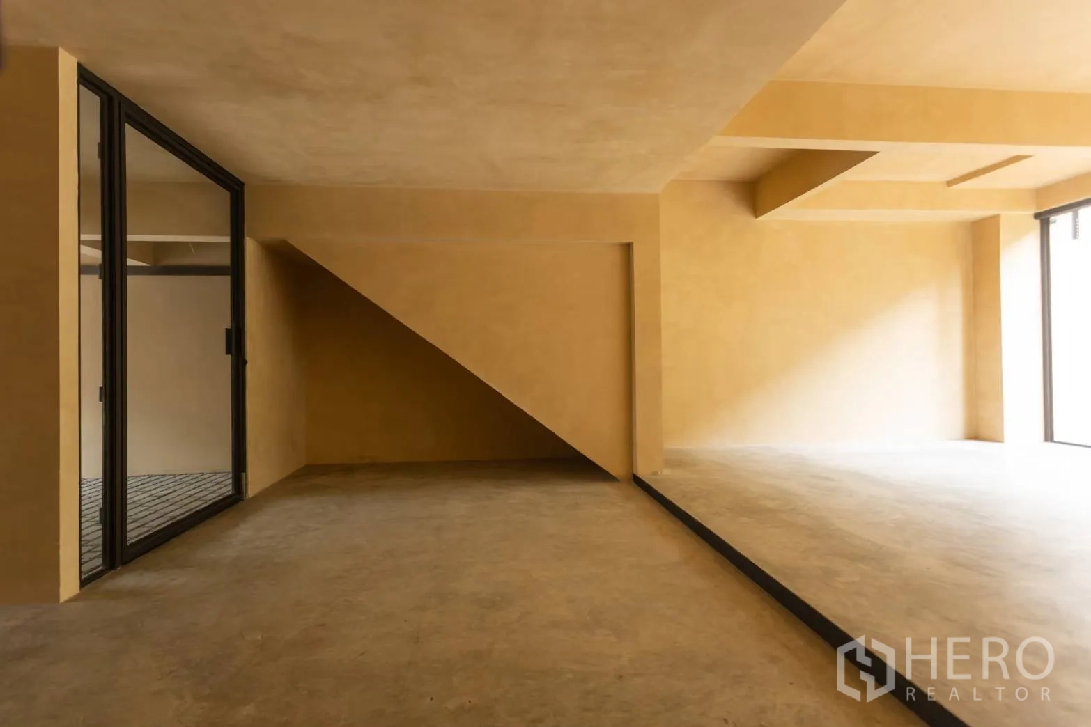 带办公室的家 出租在Watthana, Bangkok - 楼梯下空间与错层水泥工作区，自然采光。