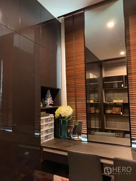 Townhouse for rent in Suan Luang, Bangkok - Walk-in closet and vanity area with high-gloss wardrobes and a large mirror.