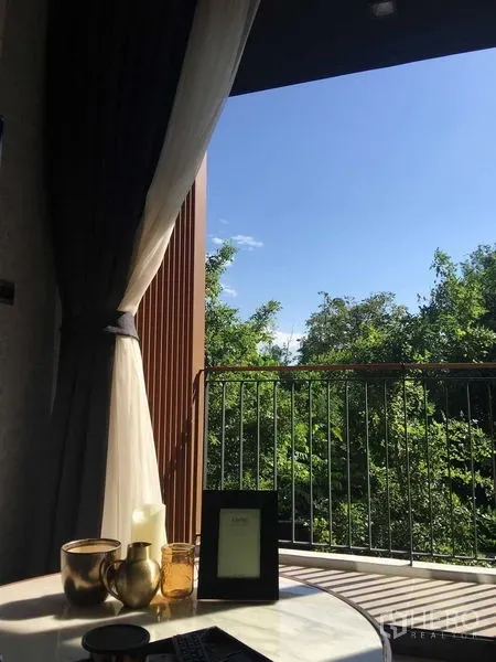 公寓 出租在Watthana, Bangkok - 阳台景观，栏杆与晨光映入，俯瞰树梢。