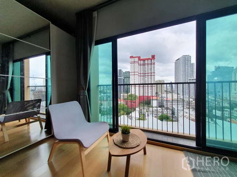 公寓 出租在Ratchathewi, Bangkok - 阳台一角放置躺椅与茶几，俯瞰曼谷天际线。