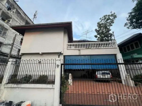 Detached House for sale in Phra Khanong, Bangkok - Gated front facade of a two-storey detached house with carport.