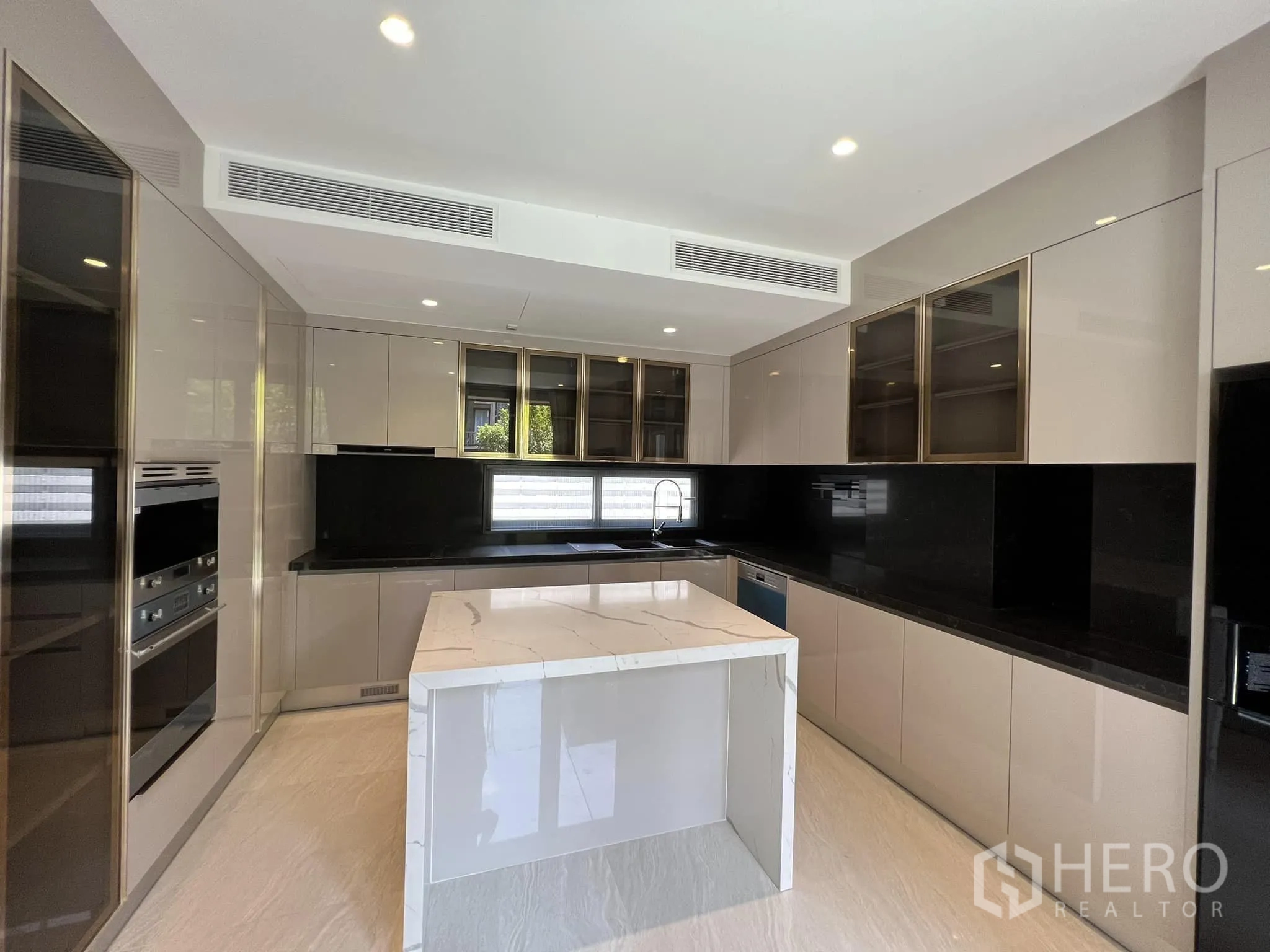 Detached House for rent or sale in Yan Nawa, Bangkok - Fully fitted kitchen with glossy cabinetry, black backsplash and marble island.