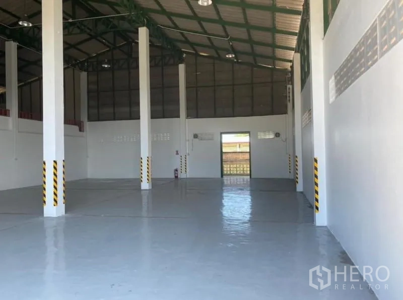 货栈 出租在Mueang Rayong, Rayong - 仓库内部开阔，高屋顶钢结构与亮面地坪。