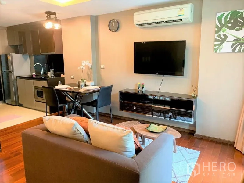 คอนโด ให้เช่าในWatthana, Bangkok - พื้นที่นั่งเล่นพร้อมทีวียึดผนัง เครื่องปรับอากาศ โต๊ะทานอาหาร และครัวบิวท์อิน