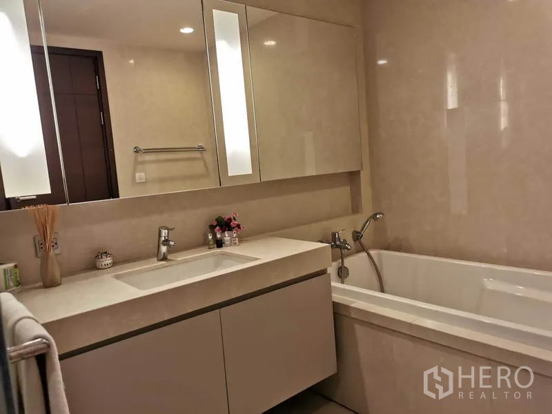 Condominium for rent in Watthana, Bangkok - Contemporary bathroom featuring a long vanity, mirrored cabinets and a bathtub.