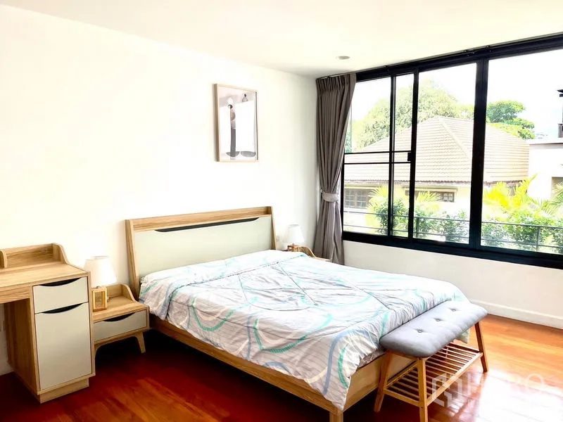 Townhouse for rent in Khlong Toei, Bangkok - Corner bedroom with big windows, double bed and green neighborhood outlook.