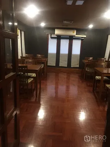 Retail Space for rent in Khlong Toei, Bangkok - Spacious dining hall with wooden tables and chairs, parquet floors and ceiling lights.