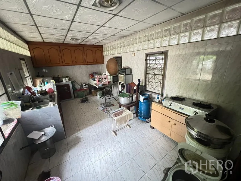 独立式住宅 出售在Phra Khanong, Bangkok - 泰式厨房，墙面贴砖，配燃气炉、水槽与储物柜。