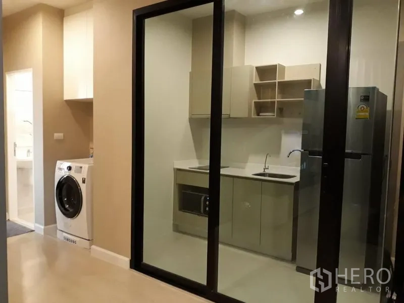 คอนโด ให้เช่าในHuai Khwang, Bangkok - ครัวปิดกั้นด้วยกระจกบานเลื่อน ตู้บิลท์อิน ซิงก์ ไมโครเวฟ ตู้เย็น และเครื่องซักผ้าบริเวณทางเดิน
