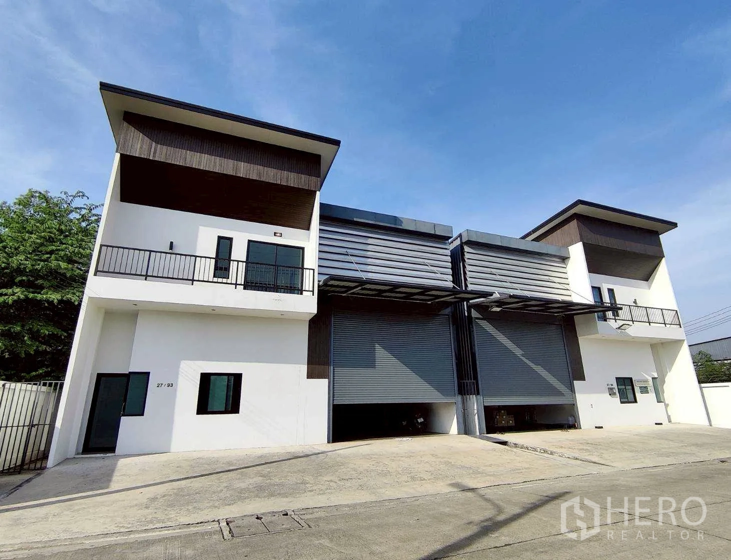 Warehouse for rent in Lam Luk Ka, Pathum Thani - Modern twin-unit warehouse exterior with motorized rolling shutters and loading ramps in Lam Luk Ka, Pathum Thani.