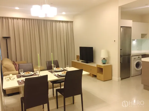 คอนโด ให้เช่าในPathum Wan, Bangkok - ห้องนั่งเล่นและรับประทานอาหารแบบโอเพ่นแปลน โต๊ะจัดเซ็ต โซฟา และทีวี ติดกับครัว