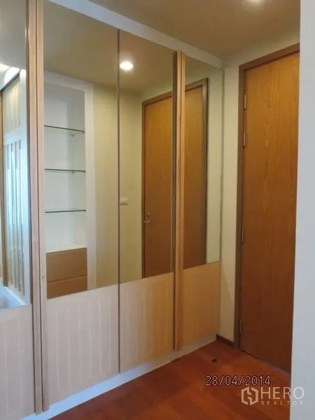 Condominium for rent in Bang Rak, Bangkok - Mirrored wardrobe doors in a dressing area adjacent to the bathroom.