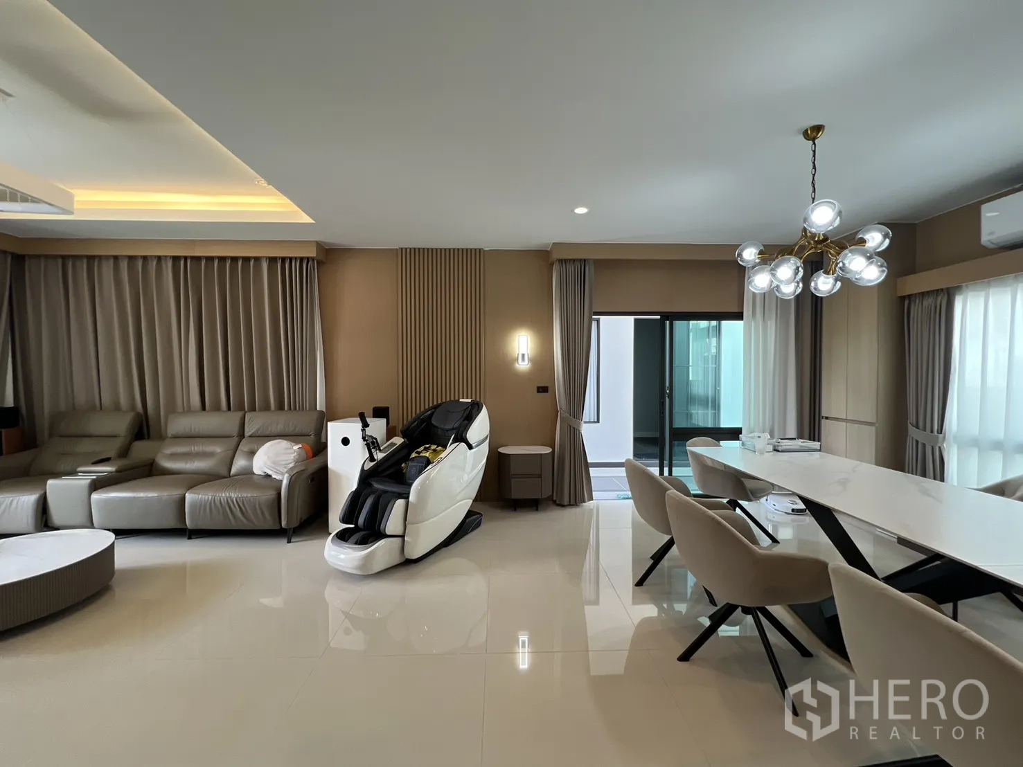 独立式住宅 出租或出售在Mueang Pathum Thani, Pathum Thani - 客餐厅一体，吊灯与皮沙发，可通往露台。
