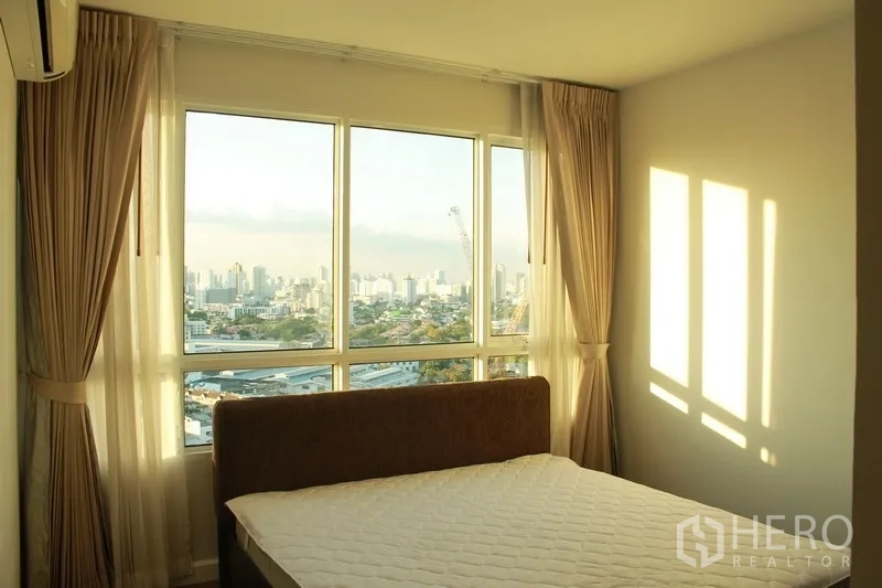 公寓 出租在Watthana, Bangkok - 卧室设大窗，可远眺曼谷天际线与城市景观，配窗帘与空调。