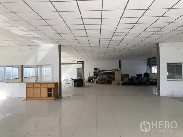 Factory for rent in Bang Phli, Samut Prakan - Open-plan office area with tiled floor, drop ceiling, and multiple windows inside the factory building.