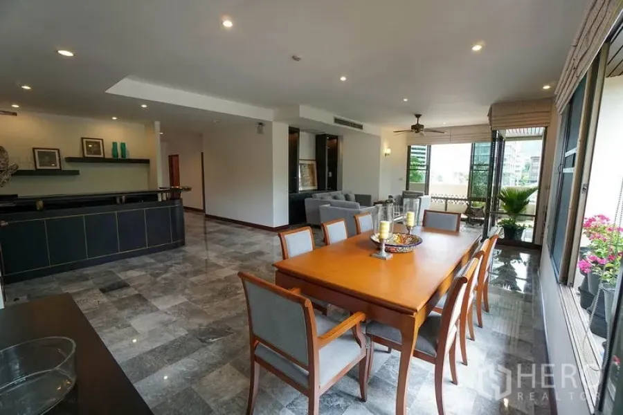 Apartment for rent in Watthana, Bangkok - Large dining room with an eight-seat table, floor-to-ceiling windows, and access to the balcony.