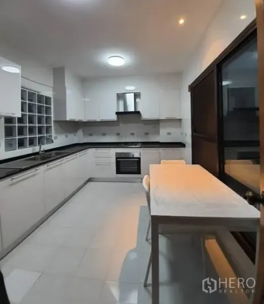 联排别墅 出租在Khlong Toei, Bangkok - 明亮白色厨房，内置橱柜、烤箱与吧台