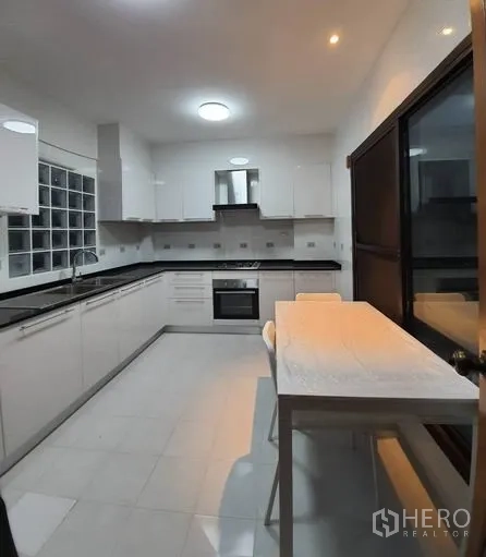联排别墅 出租在Khlong Toei, Bangkok - 明亮白色厨房，内置橱柜、烤箱与吧台
