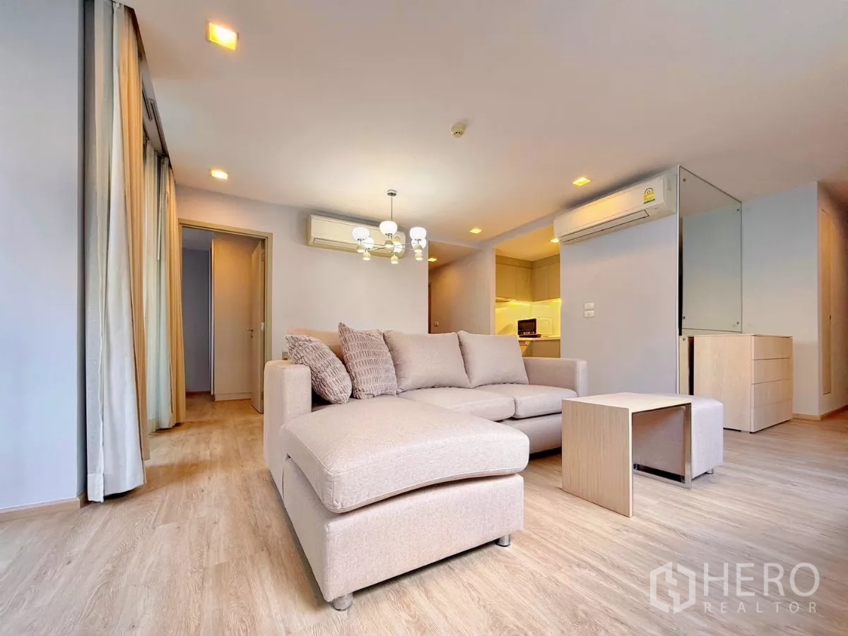 公寓 出租或出售在Watthana, Bangkok - 起居区靠近厨房入口，设转角沙发与顶灯。