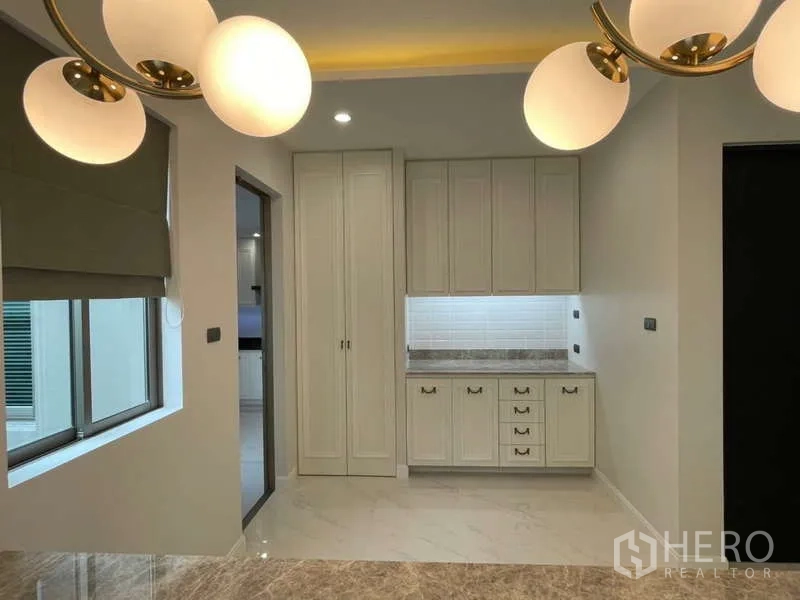 Detached House for rent or sale in Lat Krabang, Bangkok - Pantry area with classic built-in cabinets and pendant lights near the kitchen.