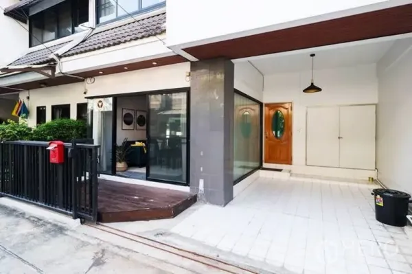 Townhouse for rent in Watthana, Bangkok - Townhouse exterior with sliding glass doors, small deck and a covered carport near Thonglor.