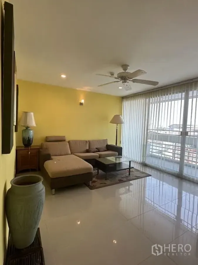 公寓 出售在Watthana, Bangkok - 宽敞客厅，落地大窗、垂直百叶与阳台出入口。