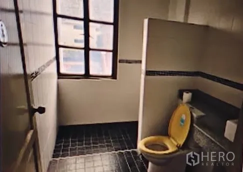 Home Office for rent in Khlong Toei, Bangkok - Tiled bathroom with window, partition wall and toilet, ready for modernization.