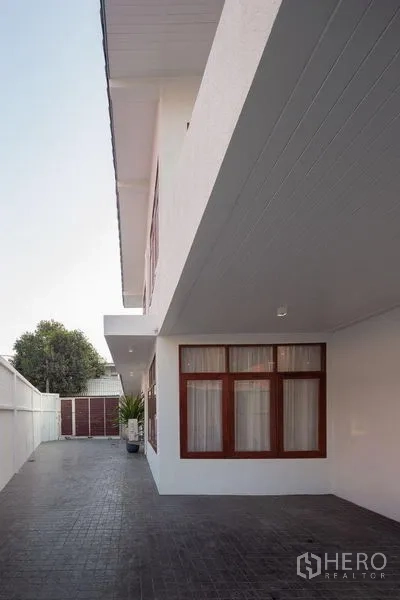 Detached House for sale in Chatuchak, Bangkok - Side elevation showing long private driveway, privacy wall and windows.