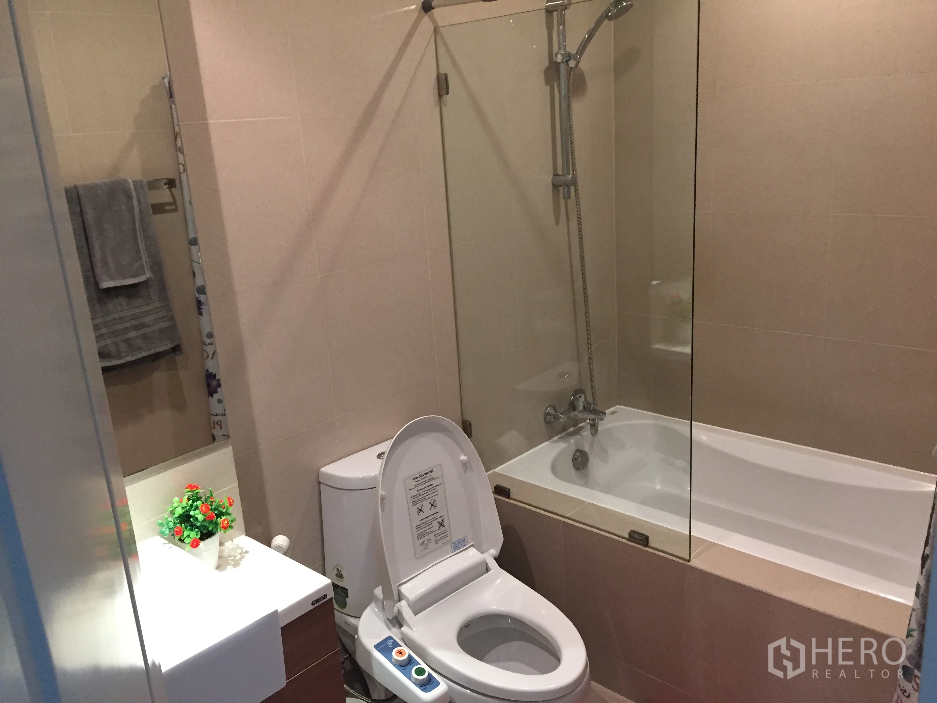 公寓 出租在Bangkok - 现代浴室，带浴缸与玻璃隔断、盥洗台和智能坐便器。