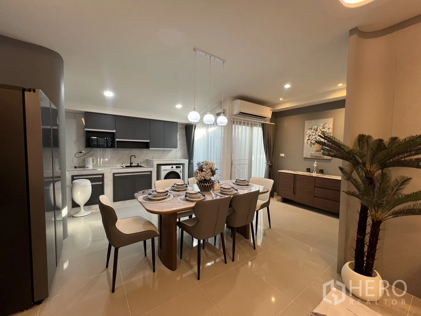 联排别墅 for rent in Bang Phli, Samut Prakan - 开放式厨房与餐区，灰色橱柜、大理石台面和吊灯。