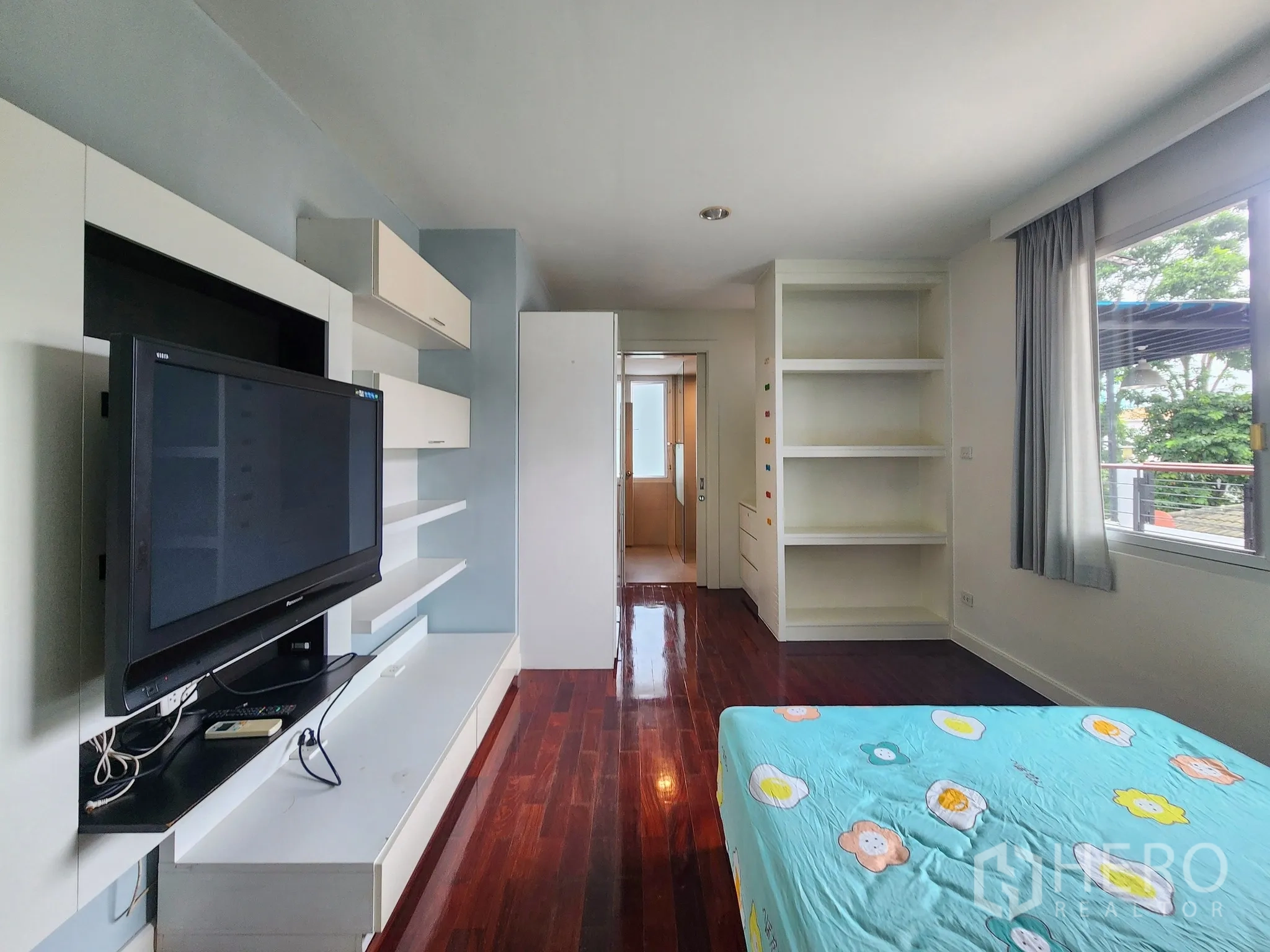 Detached House for rent in Bang Kapi, Bangkok - Third bedroom angle showing balcony outlook and glossy wood floors.