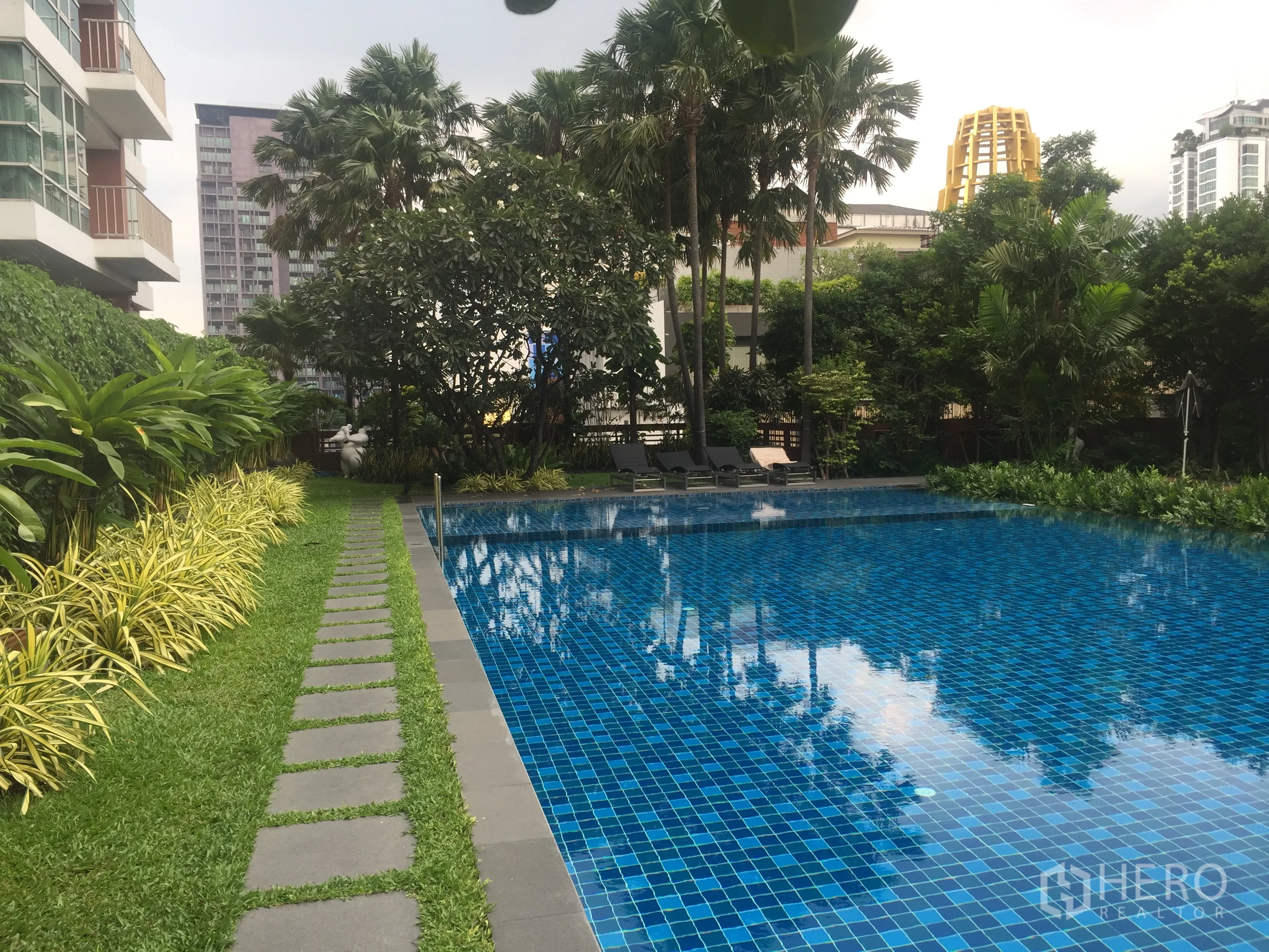 公寓 出租或出售在Watthana, Bangkok - 户外蓝色马赛克泳池，周围热带花园与躺椅