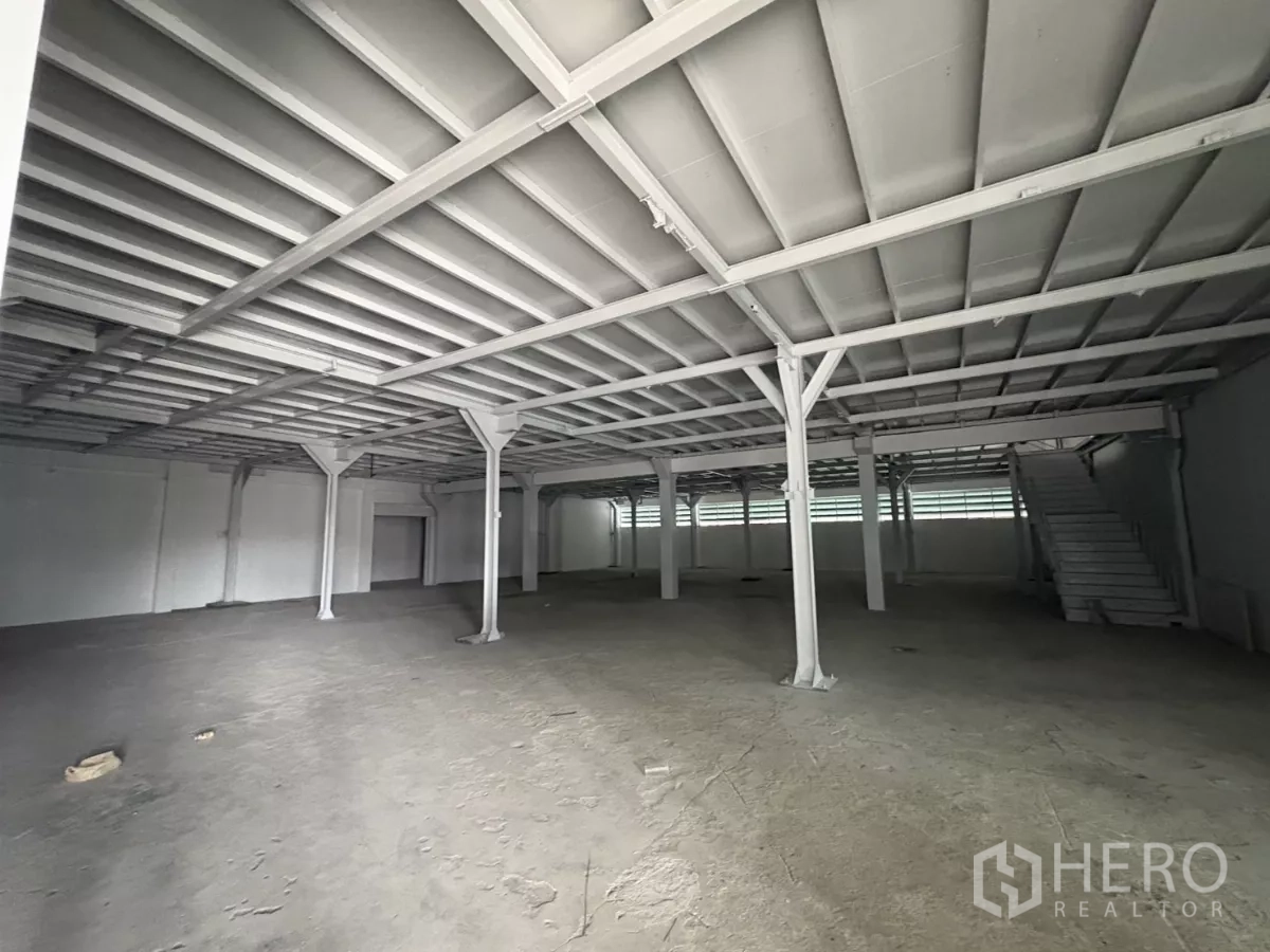 Factory for rent in Khlong Toei, Bangkok - Ground-floor warehouse area with steel columns and concrete slab floor.