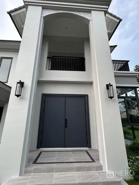 Detached House for sale in Lat Krabang, Bangkok - Grand double-height entrance with dark double doors and modern wall sconces.