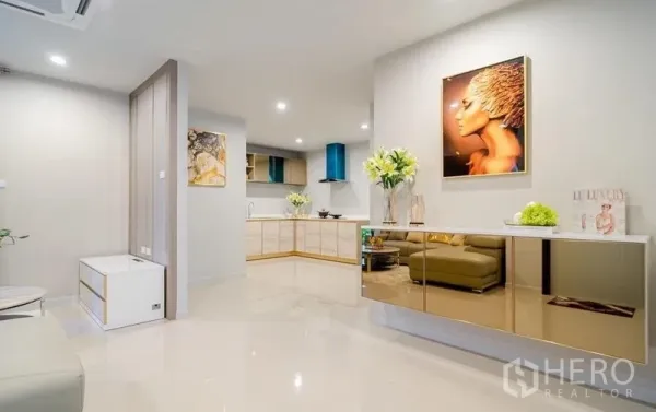 Detached House for sale in Lam Luk Ka, Pathum Thani - Bright open-plan living and kitchen with sleek cabinetry, glossy finishes, and recessed lighting.