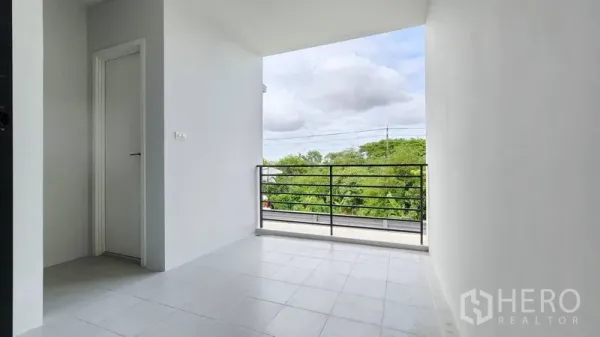 Home Office for rent - Covered balcony with tiled floor and metal railing overlooking greenery.