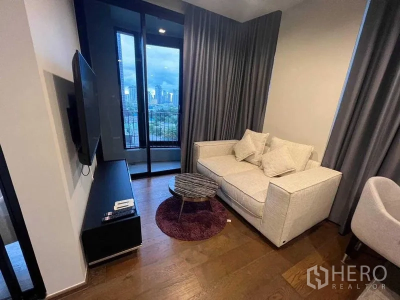 公寓 出租在Khlong Toei, Bangkok - 傍晚客厅，沙发、圆形茶几与推拉门通往阳台。