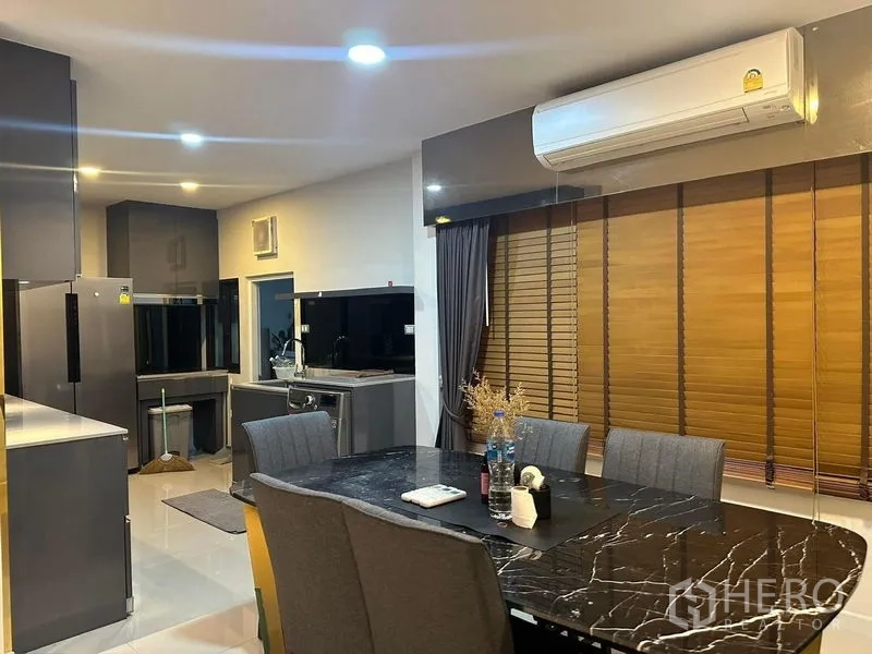 Detached House for rent in Bang Phli, Samut Prakan - Dining space with marble table beside large window and split air-conditioner.