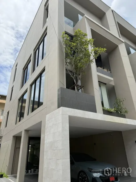 Home Office for rent or sale in Lat Phrao, Bangkok - Another exterior view of the modern four-storey building with carport and balconies.