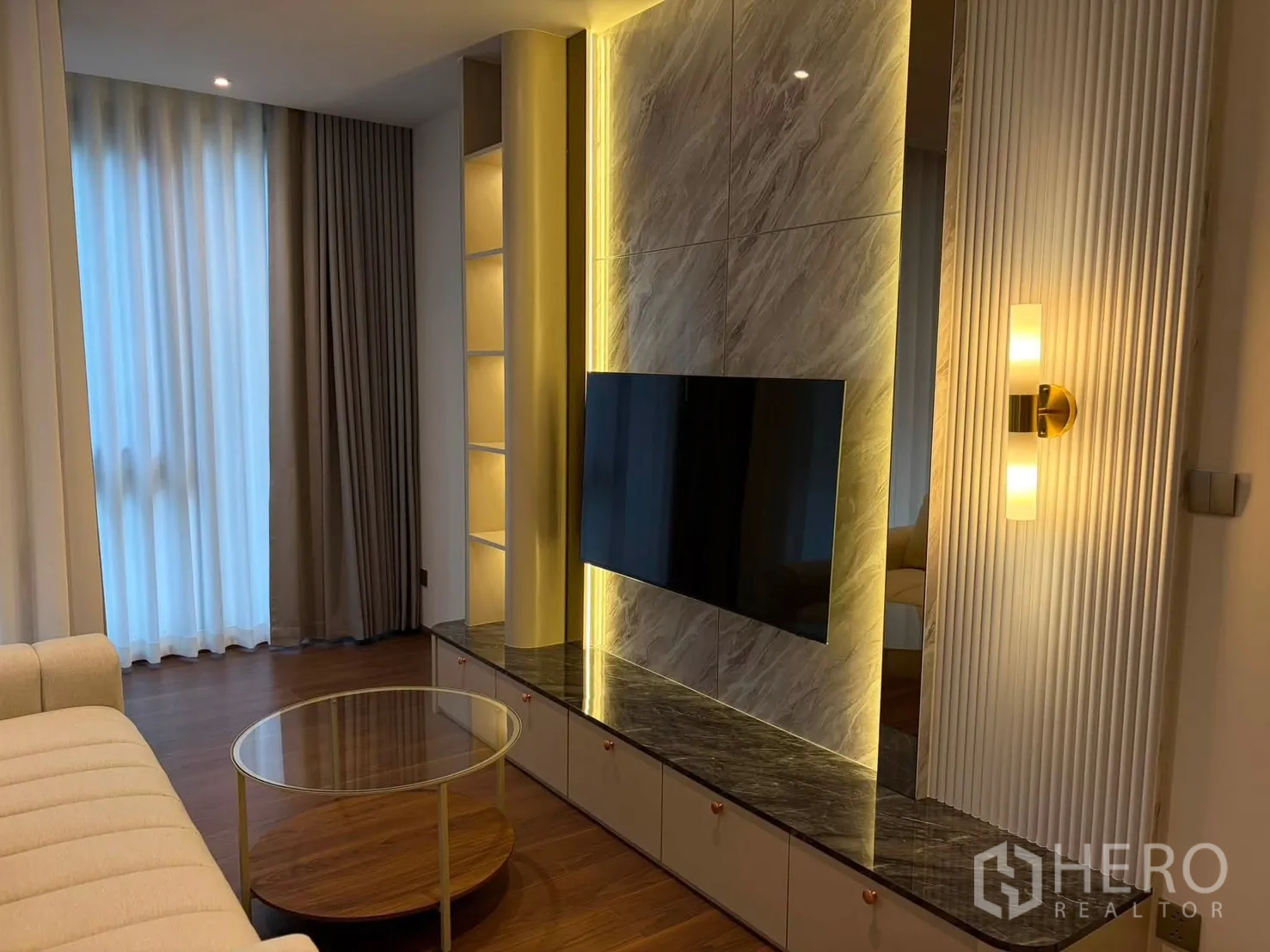 คอนโด for rent in Watthana, Bangkok - พื้นที่นั่งเล่นมีผนังทีวีลายหินพร้อมไฟซ่อนและชั้นโชว์