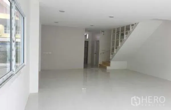 Warehouse for rent in Prawet, Bangkok - Open warehouse office area with staircase, storage niche and white tiled flooring.