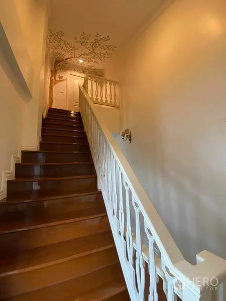 Townhouse for rent or sale in Mueang Samut Prakan, Samut Prakan - Staircase with white balustrade and hand-painted tree mural.