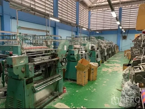 Warehouse for sale in Mueang Samut Sakhon, Samut Sakhon - Long rows of heavy-duty looms inside a ventilated warehouse hall.