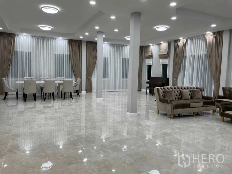 Warehouse for rent or sale in Pathum Thani - Spacious open-plan lounge and dining hall with glossy floors and full-height curtains.