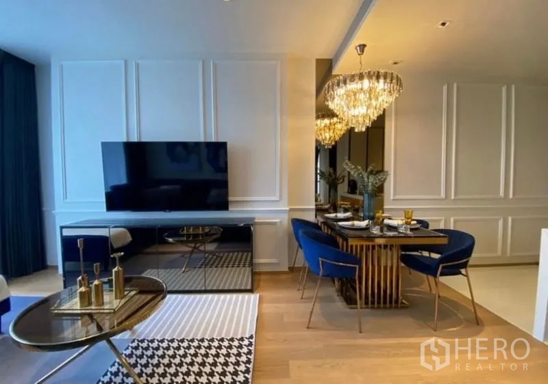 Condominium for rent - Living room with wall‑mounted TV, dining zone and light wood floors in a modern open layout.