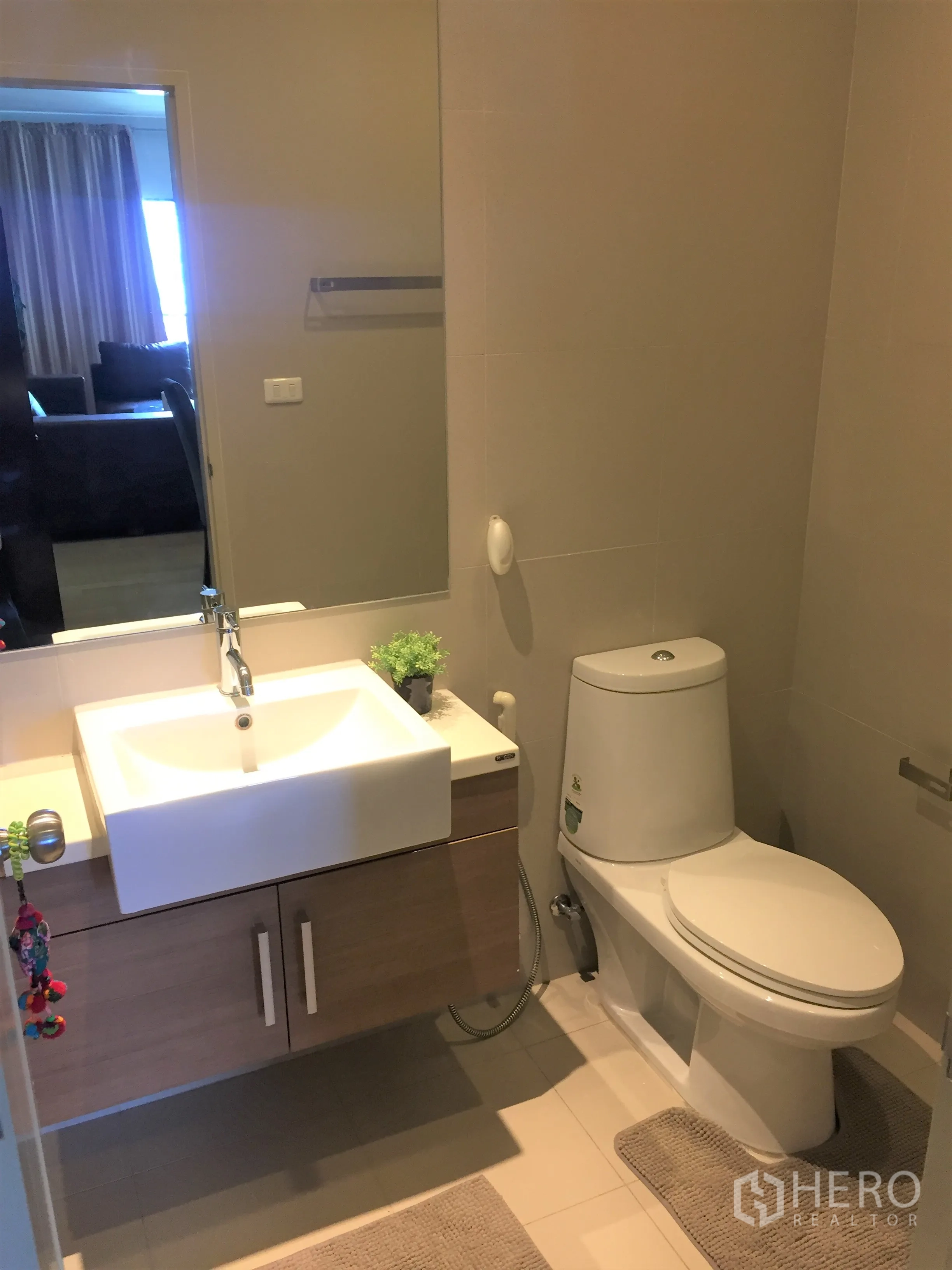 公寓 出租在Watthana, Bangkok - 现代卫浴，悬空洗手台、大镜面与坐便器，浅色瓷砖地面。