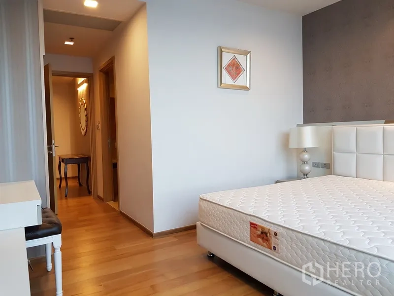 Condominium for rent in Watthana, Bangkok - Bedroom with upholstered headboard, vanity and hallway access
